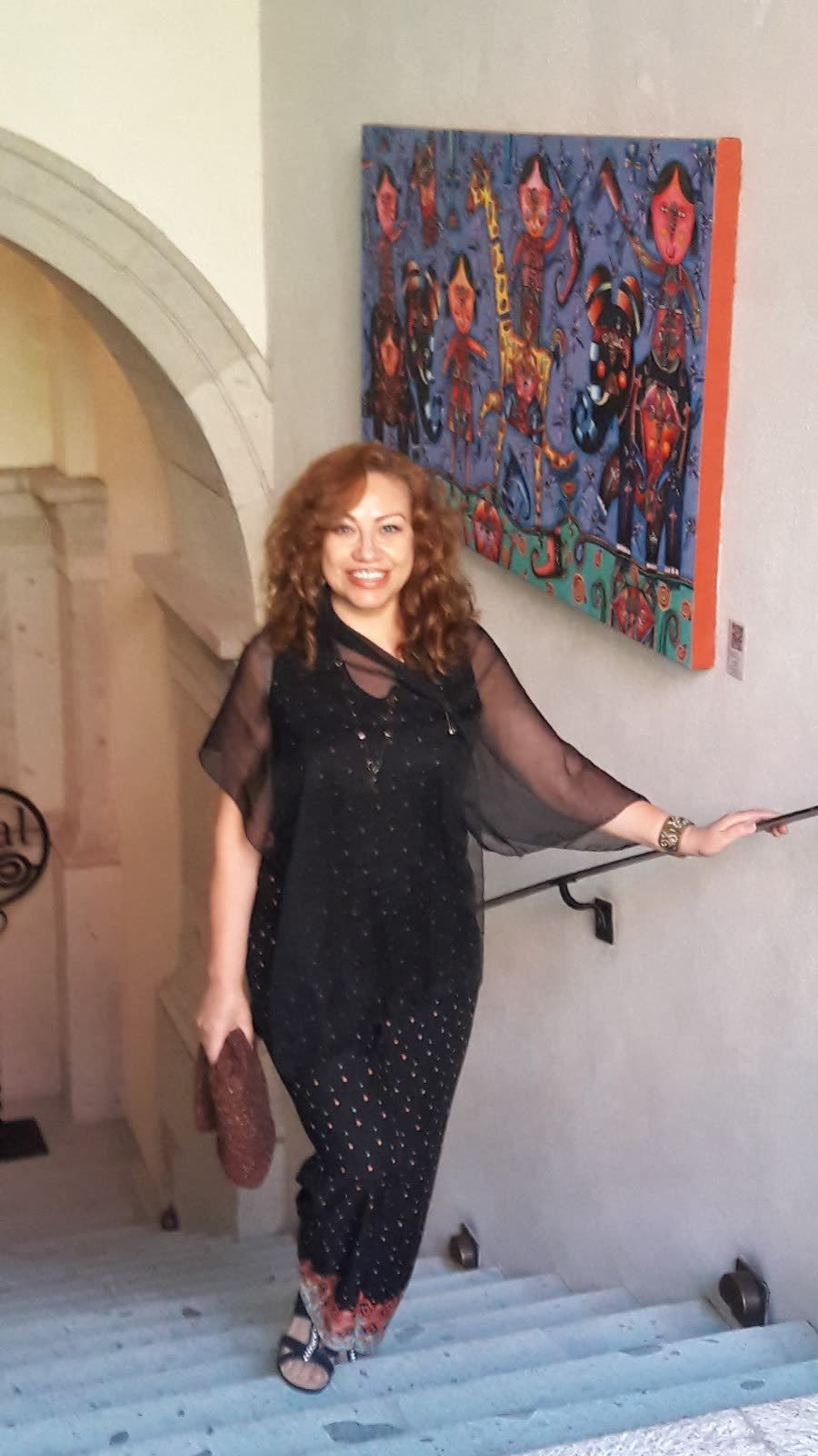 Adriana bajando una escalera, elegante, sonriente